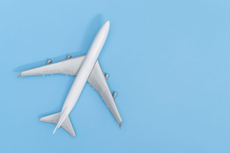 Plastic toy plane on blue copy space background for travel concept