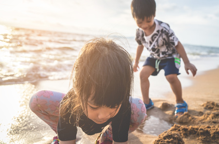 Boy and girl are having fun on Summer beach with sunlightの写真素材