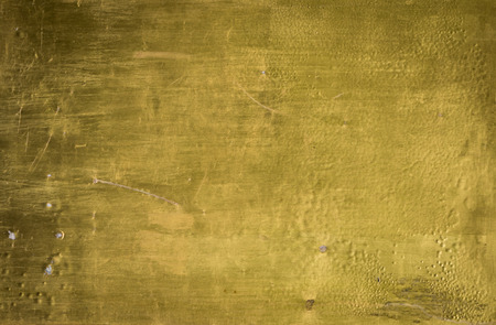 Grungy Wall painted in gold color surface textureの写真素材