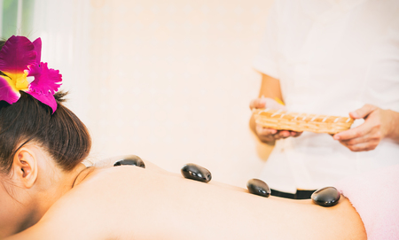 Woman back with Spa hot stone lining up on her backの写真素材