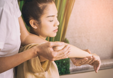 Thai Masseur is giving a massage on a woman armの写真素材