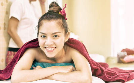 Happy woman is lying on spa bed waiting to do Spa courseの写真素材