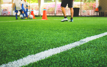Soccer training field white line with kid training in backgroundの写真素材