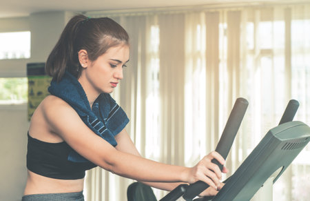 Woman is exercising on a fitness bike machine