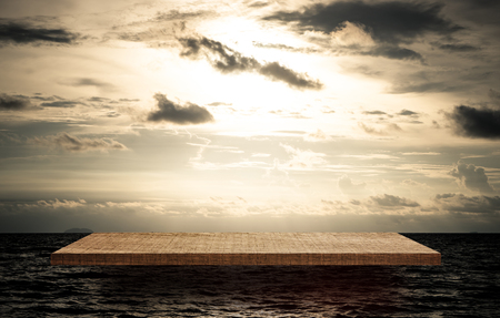 Empty wooden display shelf on Golden dramatic ocean Skyの写真素材