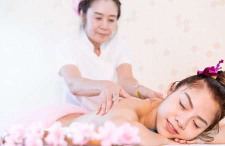 Woman is receiving oil massage on the back in Thai Massage spaの写真素材