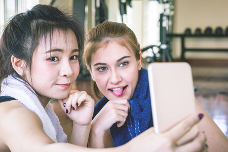 Fitness friendly girl is taking selfie photo on mobile phoneの写真素材