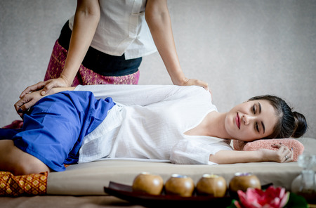 Woman is relaxing in thai Spa while massuer is massaging her armの写真素材