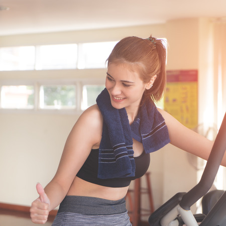 Fitness woman with thumb up for success on working out in the gymの写真素材