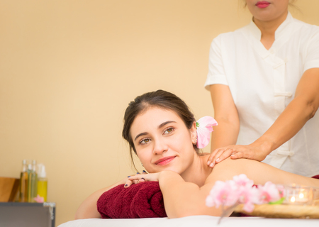 Beautiful woman is receiving back massage in Asian traditional spaの写真素材