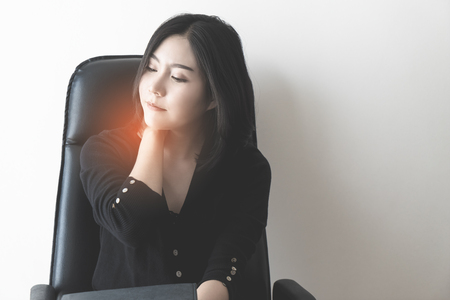 Female office worker is suffering from neck pain, office syndrome concept.の写真素材