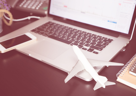Office desk with plane and laptop for business travel conceptの写真素材