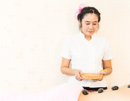 Thai Spa Therapist is giving hot stone treatment to a womanの写真素材