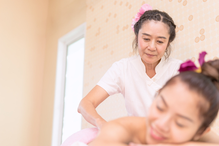 Spa Therapist is giving oil massage to a woman in Thai Spaの写真素材