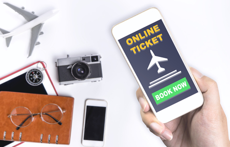 Holding online travel ticket application on mobile phoneの写真素材