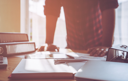 Casual business man with office desk folder and book on foregroundの写真素材