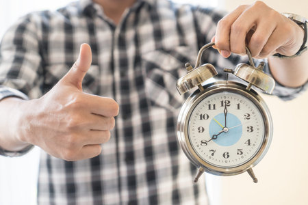 Casual business man alarm clock and thumb up