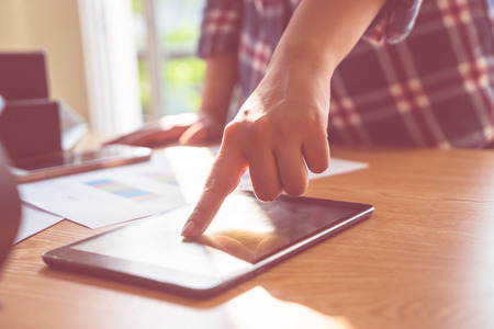 Finger touching tablet in business meeting deskの写真素材