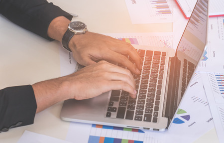 Business man hand using laptop for finance on deskの写真素材