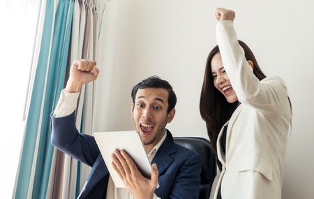 Business Boss and secretary hand up for success on report on tabletの写真素材