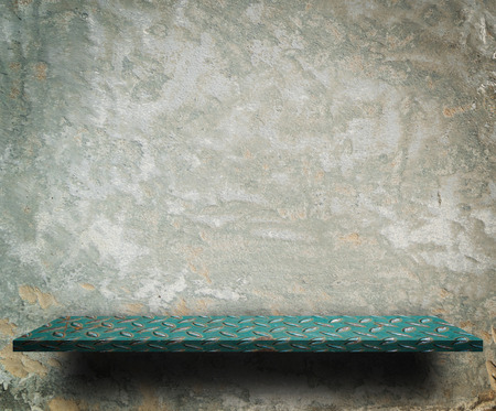 Green metal shelf display counter on grungy wallの写真素材