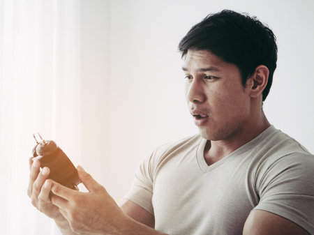Casual man is surprise on late alarm clock timeの写真素材