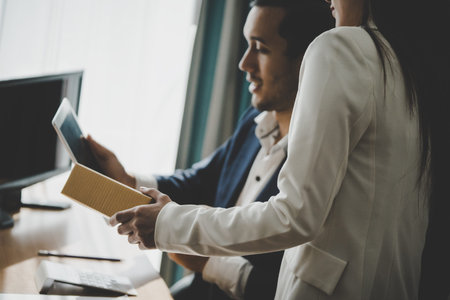 Business boss is showing secretary report on computer tablet screenの写真素材