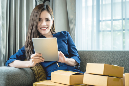 Small business woman is preparing to send out her product in boxesの写真素材