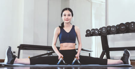 Woman is making leg split in fitness gymの写真素材