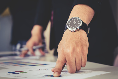 Hands pointing on data chart sheet for business meetingの写真素材