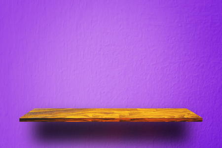 Empty wooden shelf on purple cement wallの写真素材