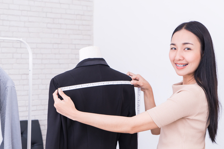 Asian woman dressmaker is measuring jacketの写真素材