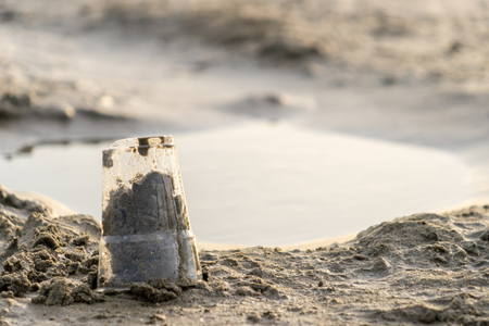 Rubbish Plastic cup left on the beach make pollutionの写真素材