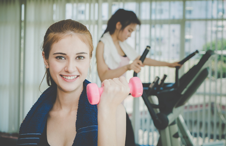 Asian woman is lifting dumbbell in fitnessの写真素材