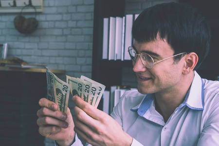 Business man is counting of more money working onlineの写真素材