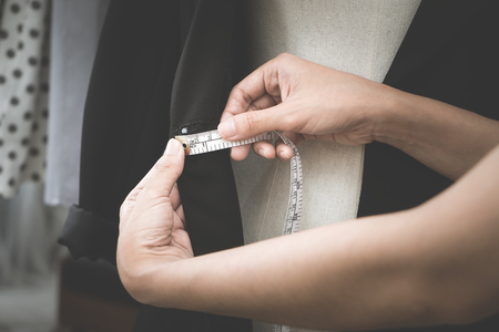 Fashion Designer hand is measuring jacket with measuring tapeの写真素材