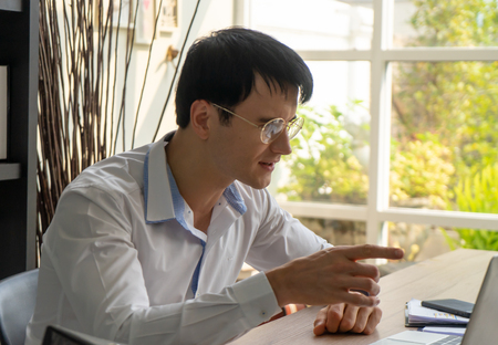Business Man happily pointing at the stock trading data as the stock is going up.の写真素材