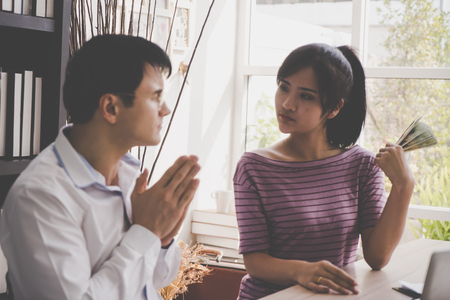 Poor husband begging his wife for moneyの写真素材