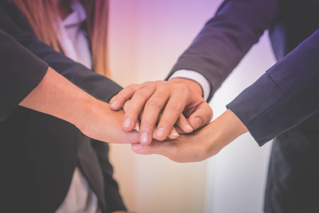 Four hand together in business meeting for team concept