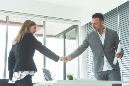 Male boss fist bump with female worker for successの写真素材