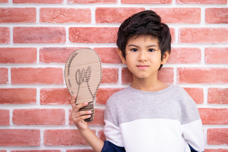 Kid holding paper bulb for idea conceptの写真素材