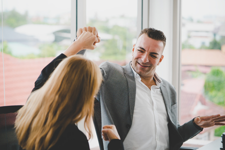 Male boss fist bump with female worker for successの写真素材