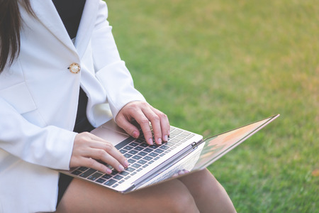Office woman hand is typing on business computer outdoorの写真素材