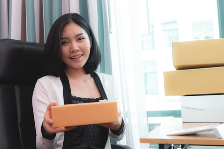 Start up business woman is holding delivery boxes ready to send out to customerの写真素材