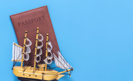 Toy plane on top of passport on blue copy space