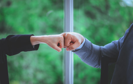 Business man and woman business couple fist bump hand together for team work