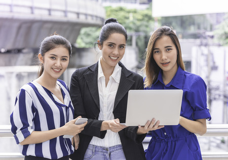Office workers business woman friend is happy teamwork on laptop outdoorの写真素材