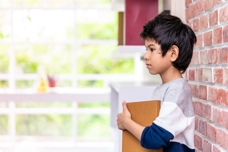Asian boy is holding book side viewの写真素材