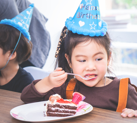 Asian girl is happy eating her birthday cakeの写真素材