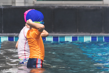 Asian sibling are playing in swimming poolの写真素材